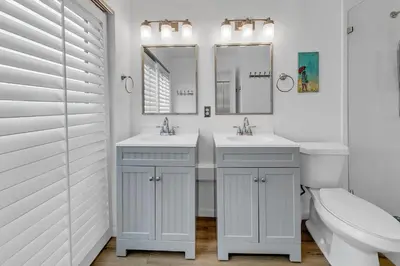 a white bathroom with two sinks and a toilet at Largo Mar 106 by Emerald Coast Retreats in Panama City Beach