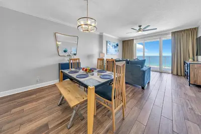 a living room with a dining room table and a couch at Ocean Reef 1204 in Panama City Beach