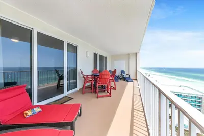 a balcony with red chairs and tables and the ocean at Ocean Reef 1204 in Panama City Beach
