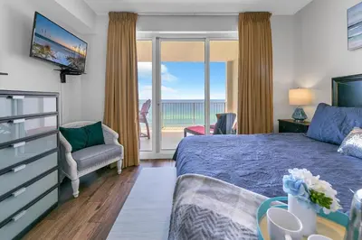 a bedroom with a bed and a view of the ocean at Ocean Reef 1204 in Panama City Beach