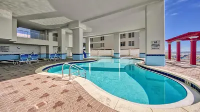 a pool in the middle of a building with chairs at Beachfront Unit-Majestic Beach Resort in Panama City Beach