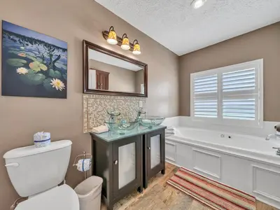 a bathroom with a tub and a toilet and a sink at Sunset Sanctuary by Emerald Coast Retreats in Panama City Beach