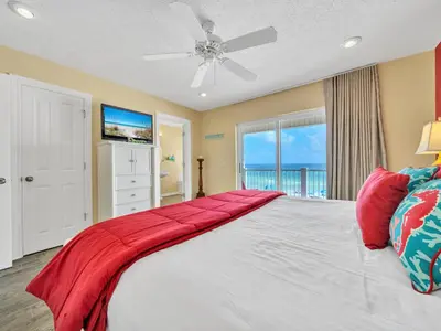 a bedroom with a large bed with a ceiling fan at Sunset Sanctuary by Emerald Coast Retreats in Panama City Beach