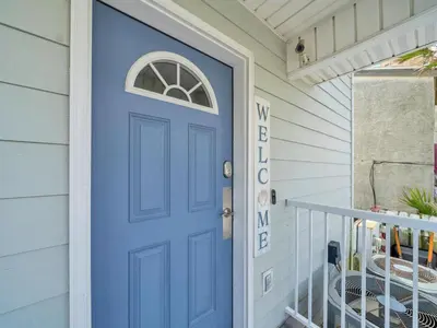 a blue door on a house with a porch at Sunset Sanctuary by Emerald Coast Retreats in Panama City Beach