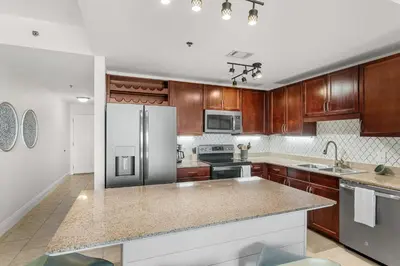 a kitchen with wooden cabinets and a stainless steel refrigerator at Laketown Wharf #0628 in Panama City Beach