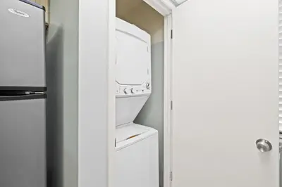 a kitchen with a washer and dryer next to a door at Edgewater Golf Villa 605 in Panama City Beach
