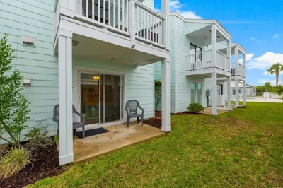 a house with a balcony and a lawn at Southwinds Unit D3 in Panama City Beach
