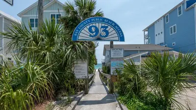 a sign for a hotel on a beach with palm trees at Villas Bahama West 106 in Panama City Beach
