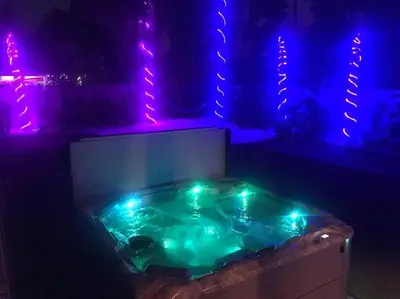 a hot tub with blue and purple lights in a room at Tropical Oasis, Tiki Bar, Pool, Mini Golf, Hot Tub in Panama City Beach