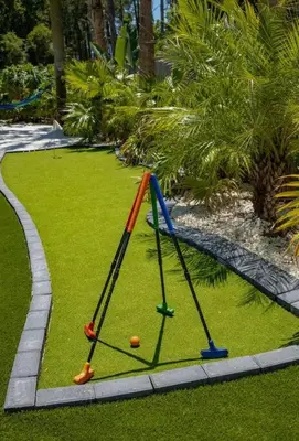 a playground with a swing set on the grass at Tropical Oasis, Tiki Bar, Pool, Mini Golf, Hot Tub in Panama City Beach