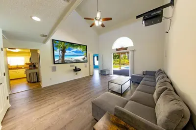 a living room with a couch and a ceiling fan at Tropical Oasis, Tiki Bar, Pool, Mini Golf, Hot Tub in Panama City Beach