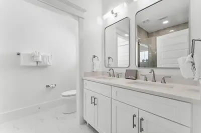 a white bathroom with two sinks and a toilet at Cottages at Eastern Lake by Panhandle Getaways in Santa Rosa Beach