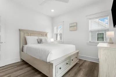 a white bedroom with a bed and two windows at Cottages at Eastern Lake by Panhandle Getaways in Santa Rosa Beach