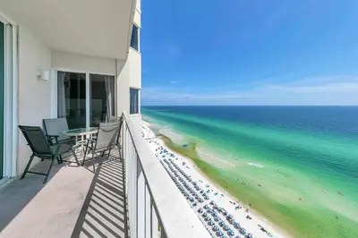 a balcony with a table and chairs and the ocean at Tidewater 1802 in Panama City Beach
