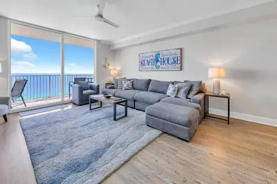 a living room with a couch and a large window at Tidewater 1802 in Panama City Beach