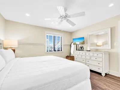 a white bedroom with a bed and a ceiling fan at Latitude 29 #36 in Panama City Beach