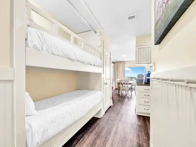 a bedroom with two bunk beds and a desk at Latitude 29 #36 in Panama City Beach