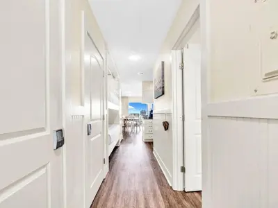 a hallway with white doors and a wooden floor at Latitude 29 #36 in Panama City Beach