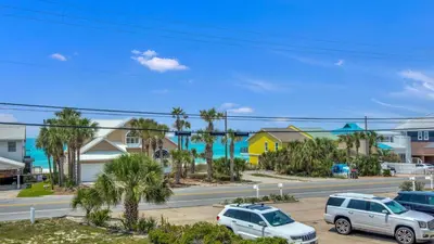 two cars parked in a parking lot in front of houses at Bahama West by Panhandle Getaways in Panama City Beach