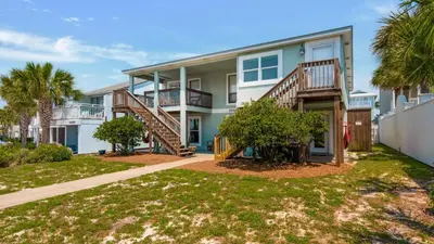 a large house with stairs and a yard at Bahama West by Panhandle Getaways in Panama City Beach