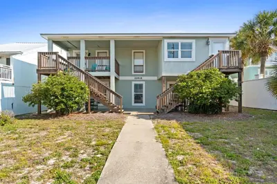 a house with stairs and trees in front of it at Bahama West by Panhandle Getaways in Panama City Beach