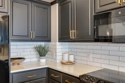 a kitchen with black cabinets and a counter top at Newly Renovated Luxury OCEAN FRONT Condo! Top Floor Condo with PENTHOUSE OCEAN VIEWS! in Panama City Beach