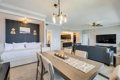 a living room with a bed and a dining table at Newly Renovated Luxury OCEAN FRONT Condo! Top Floor Condo with PENTHOUSE OCEAN VIEWS! in Panama City Beach