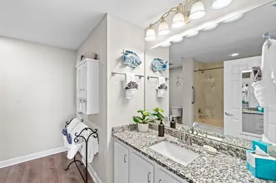 a bathroom with a sink and a large mirror at Coral Charm in Panama City Beach