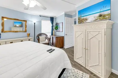 a bedroom with a white bed and a mirror at Edgewater Tower 1-105 in Panama City Beach