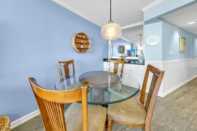 a dining room with a glass table and chairs at Edgewater Tower 1-105 in Panama City Beach