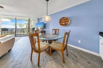 a dining room with a table and chairs and a balcony at Edgewater Tower 1-105 in Panama City Beach