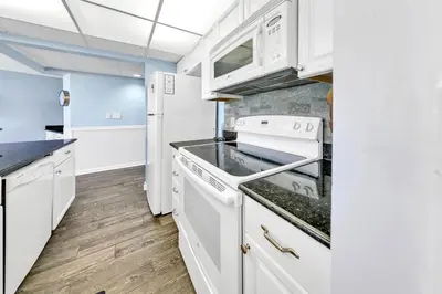 a kitchen with white cabinets and a stove at Edgewater Tower 1-105 in Panama City Beach