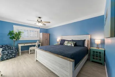 a bedroom with blue walls and a bed and a desk at Deep Savings While Regency Updates Oct-March in Panama City Beach