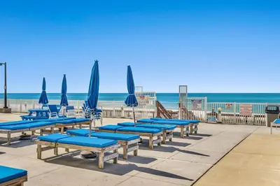 a row of blue chairs and umbrellas on a beach at Deep Savings While Regency Updates Oct-March in Panama City Beach