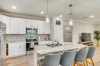 a kitchen with white cabinets and a marble counter top at Family-Friendly Panama City Home Less Than 1 Mi to Beach in Panama City