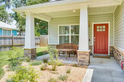 a house with a red door and a bench at Family-Friendly Panama City Home Less Than 1 Mi to Beach in Panama City