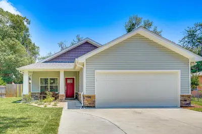 a house with a red door and a garage at Family-Friendly Panama City Home Less Than 1 Mi to Beach in Panama City