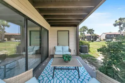 a screened in porch with a table and a couch at Portside P1 in Panama City Beach