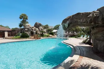 a swimming pool with a waterfall in a resort at Portside P1 in Panama City Beach
