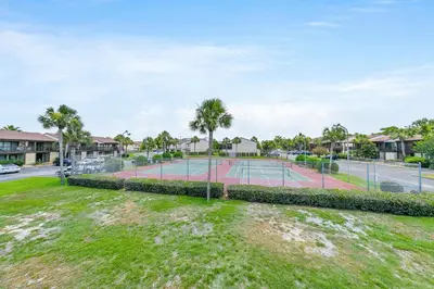 a tennis court with palm trees in a park at Portside P1 in Panama City Beach