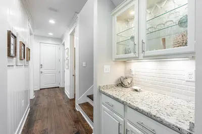 a kitchen with white cabinets and a counter top at Plimsoll Retreat at Watersound West Beach in Santa Rosa Beach