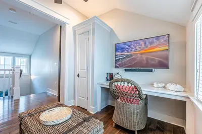 a living room with a desk and a chair at Plimsoll Retreat at Watersound West Beach in Santa Rosa Beach