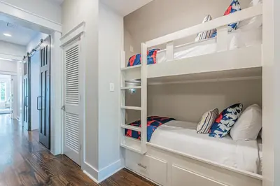 a bedroom with two bunk beds and a hallway at Plimsoll Retreat at Watersound West Beach in Santa Rosa Beach
