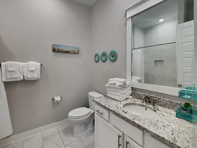 a white bathroom with a toilet and a sink at Prominence North #54A - Barefoot Bungalow in Inlet Beach