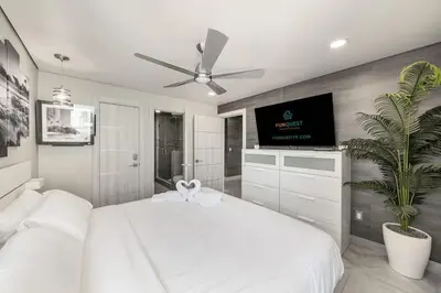 a bedroom with a white bed and a flat screen tv at The Summit 1001 in Panama City Beach