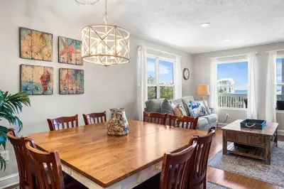 a dining room with a table and a couch at Serenity - Inlet Beach in Inlet Beach