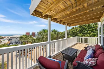 a porch with a couch and chairs on a balcony at Serenity - Inlet Beach in Inlet Beach
