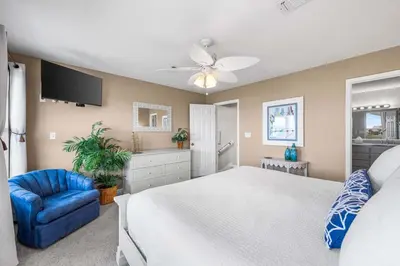 a bedroom with a white bed and a blue chair at Serenity - Inlet Beach in Inlet Beach