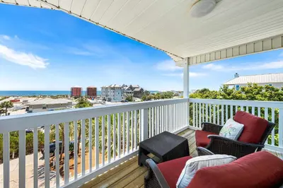 a porch with two chairs and a balcony with the ocean at Serenity - Inlet Beach in Inlet Beach