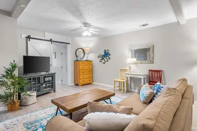 a living room with a couch and a tv at Serenity - Inlet Beach in Inlet Beach